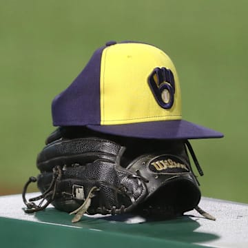 Jul 27, 2020; Pittsburgh, Pennsylvania, USA;  A Milwaukee Brewers hat and glove on the dugout rail against the Pittsburgh Pirates during the tenth inning at PNC Park.Milwaukee won 6-5 in eleven innings.  Mandatory Credit: Charles LeClaire-Imagn Images