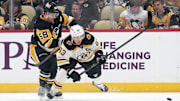 Mar 1, 2025; Pittsburgh, Pennsylvania, USA;  Pittsburgh Penguins defenseman Kris Letang (58) checks Boston Bruins left wing Brad Marchand (63) during the first period at PPG Paints Arena. Mandatory Credit: Charles LeClaire-Imagn Images