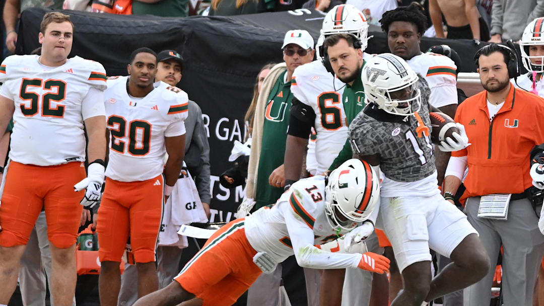 Nov 22, 2025; Blacksburg, Virginia, USA;  Miami (FL) Hurricanes defensive back Bryce Fitzgerald (13) tackles Virginia Tech Hokies wide receiver Isaiah Spencer (11)during the fourth quarter at Lane Stadium. Mandatory Credit: Brian Bishop-Imagn Images