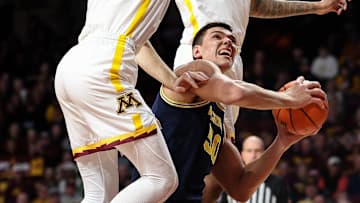 Jan 16, 2025; Minneapolis, Minnesota, USA; Michigan Wolverines center Vladislav Goldin (50) shoots as Minnesota Golden Gophers forward Parker Fox (23) and guard Femi Odukale (11) defend during the second half at Williams Arena. Mandatory Credit: Matt Krohn-Imagn Images