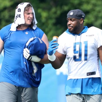 Detroit Lions offensive lineman Colby Sorsdal, left, and defensive end Levi Onwuzurike walk off the field 