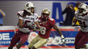 Dec 31, 2010; Atlanta, GA, USA; South Carolina Gamecocks cornerback Stephon Gilmore (5) runs with an interception in front of Florida State Seminoles wide receiver Taiwan Easterling (8) during the third quarter in the 2010 Chick-fil-A Bowl at the Georgia Dome. Florida State defeated South Carolina 26-17. Mandatory Credit: Dale Zanine-Imagn Images
