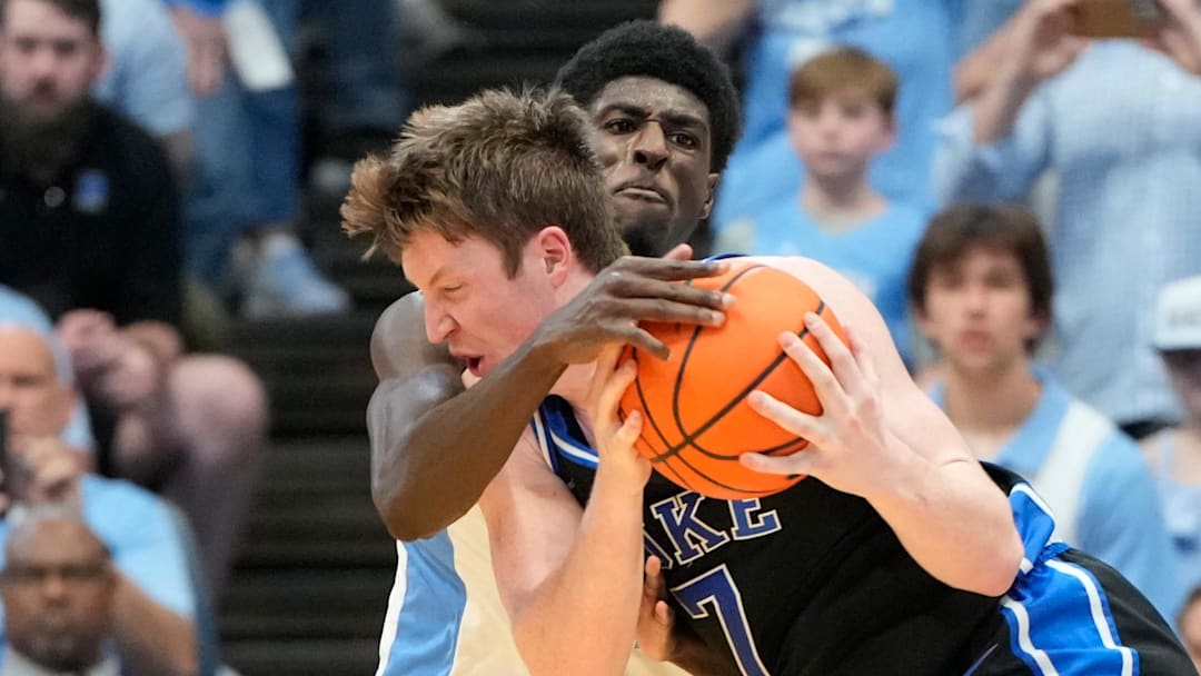 Mar 8, 2025; Chapel Hill, North Carolina, USA;  Duke Blue Devils guard Kon Knueppel (7) with the ball as North Carolina Tar Heels guard Drake Powell (9) defends in the second half at Dean E. Smith Center. Mandatory Credit: Bob Donnan-Imagn Images