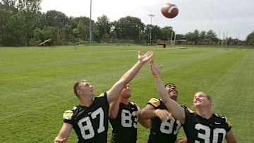 Iowa tight ends Scott Chandler, Brandon Myers, Tony Moeaki, and Ryan Majerus reach for the ball for a photo at Iowa football media day on Aug. 7, 2004.

Title Iowa Football Media Day