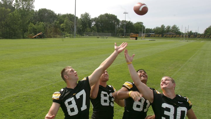 Iowa tight ends Scott Chandler, Brandon Myers, Tony Moeaki, and Ryan Majerus reach for the ball for a photo at Iowa football media day on Aug. 7, 2004.

Title Iowa Football Media Day