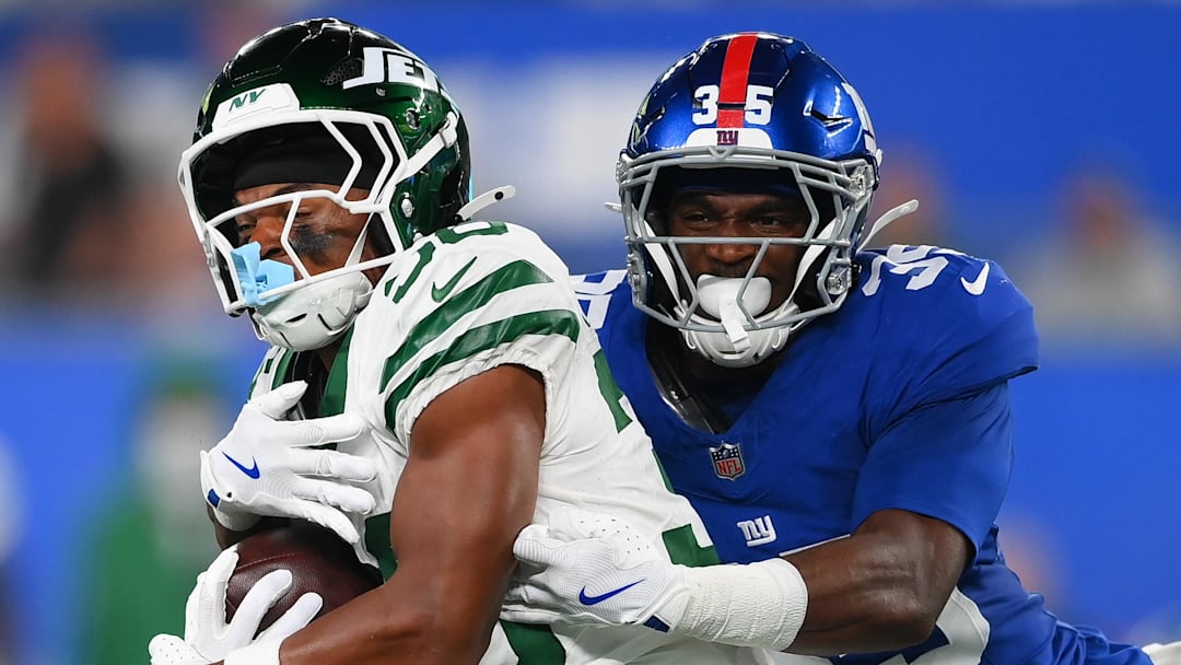 New York Giants cornerback Art Green tackles New York Jets wide receiver Jamaal Pritchett