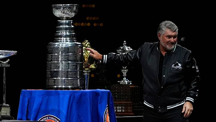 Jan 23, 2026; Denver, Colorado, USA; Former canadian professional ice hockey player Ray Bourque touches the 2001 Stanley Cup before the game between the Philadelphia Flyers against the Colorado Avalanche at Ball Arena. Mandatory Credit: Ron Chenoy-Imagn Images