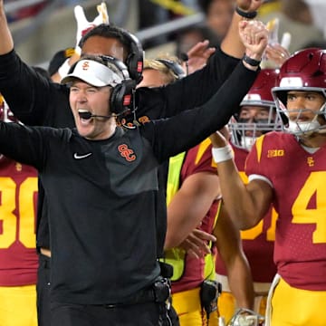 Oct 11, 2025; Los Angeles, California, USA;  USC Trojans head coach Lincoln Riley (wearing white visor) celebrates along with defensive end coach Shaun Nua after kicker Ryon Sayeri (48) hit a 54-yard field goal in the second half against the Michigan Wolverines at United Airlines Field at the Los Angeles Memorial Coliseum. Mandatory Credit: Jayne Kamin-Oncea-Imagn Images