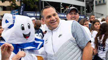 Penn State athletic director Pat Kraft, right, poses for a photo with a group of costumed fans outside Beaver Stadium before a Big Ten football game against Illinois, Saturday, Sept. 28, 2024, in State College, Pa.
