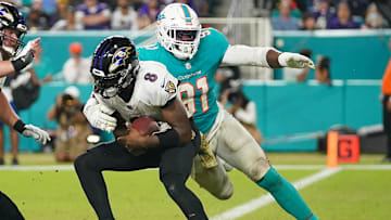 Nov 11, 2021; Miami Gardens, Florida, USA; Baltimore Ravens quarterback Lamar Jackson (8) breaks the sack attempt of Miami Dolphins defensive end Emmanuel Ogbah (91) during the second half at Hard Rock Stadium. Mandatory Credit: Jasen Vinlove-Imagn Images