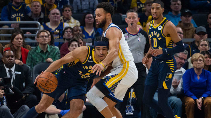 Dec 14, 2022; Indianapolis, Indiana, USA; Indiana Pacers guard Andrew Nembhard (2) dribbles against Golden State Warriors guard Stephen Curry (30) in the first quarter at Gainbridge Fieldhouse. Mandatory Credit: Trevor Ruszkowski-USA TODAY Sports