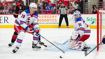 Apr 12, 2025; Raleigh, North Carolina, USA;  New York Rangers left wing Chris Kreider (20) picks up the puck in front of goaltender Igor Shesterkin (31) against the Carolina Hurricanes during the third period at Lenovo Center. Mandatory Credit: James Guillory-Imagn Images
