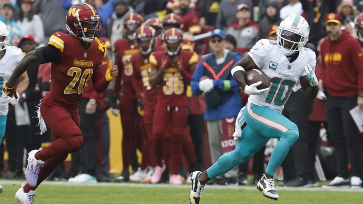 Miami Dolphins wide receiver Tyreek Hill (10) runs with the ball en route to a touchdown as Washington Commanders safety Jartavius Martin (20) chases during the first quarter at FedExField last season.