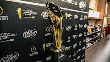 Fans stop to take photos with the College Football National Championship trophy at Meijer in Ypsilanti, Mich. on Thursday, Jan. 11, 2024. The trophy is going on a tour for fans to see presented by Dr. Pepper.