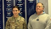 Head coach Bill Belichick and Staff Sgt. Veneta Wheeler of the UNC Army ROTC in frnt of the "Honroring Our Military" wall.