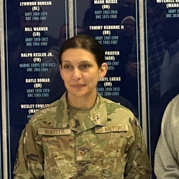 Head coach Bill Belichick and Staff Sgt. Veneta Wheeler of the UNC Army ROTC in frnt of the "Honroring Our Military" wall.