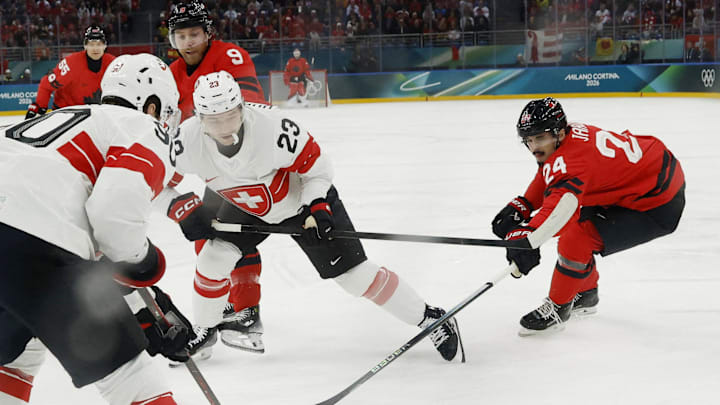 Feb 13, 2026; Milan, Italy; Seth Jarvis of Canada in action with Philipp Kurashev and Roman Josi of Switzerland in men's ice hockey group A play during the Milano Cortina 2026 Olympic Winter Games at Milano Santagiulia Ice Hockey Arena. Mandatory Credit: Geoff Burke-Imagn Images