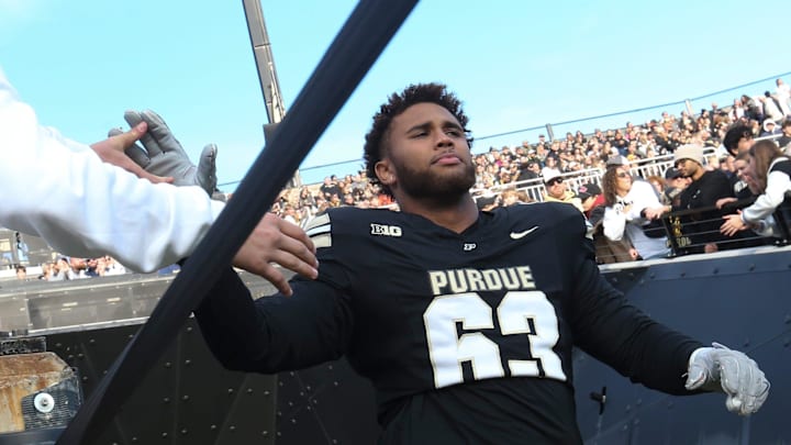 Purdue Boilermakers offensive lineman Marcus Mbow (63) high-fives a fan Purdue Boilermakers offensive lineman Marcus Mbow (63) high-fives a fan