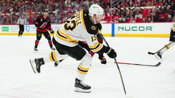 Mar 6, 2025; Raleigh, North Carolina, USA;  Boston Bruins center Charlie Coyle (13) takes a shot ]against the Carolina Hurricanes during the second period at Lenovo Center. Mandatory Credit: James Guillory-Imagn Images