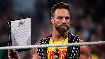 WWE Superstar L.A. Knight holds up his SummerSlam match contract against YouTube star Logan Paul.