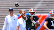 Florida Gators quarterback DJ Lagway throws a pass in front of quarterbacks coach Ryan O'Hara and head coach Billy Napier during position drills.