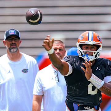 Florida Gators quarterback DJ Lagway throws a pass in front of quarterbacks coach Ryan O'Hara and head coach Billy Napier during position drills.
