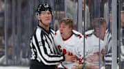 Nov 13, 2024; Salt Lake City, Utah, USA; NHL linesman Travis Toomey (90) pushes Carolina Hurricanes center Jack Drury (18) in to the penalty box after a fight against the Utah Hockey Club during the third period at Delta Center. Mandatory Credit: Rob Gray-Imagn Images