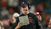 Oct 25, 2025; Miami Gardens, Florida, USA; Stanford Cardinal interim head coach Frank Reich reads a play card against the Miami Hurricanes during the third quarter at Hard Rock Stadium. Mandatory Credit: Sam Navarro-Imagn Images
