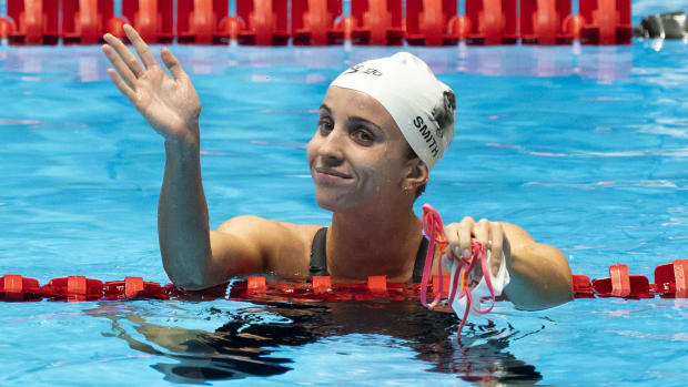 Regan Smith waves to the crowd after her heat win in 100 meter backstroke prelims at 2024 U.S. Olympic Swim Trials