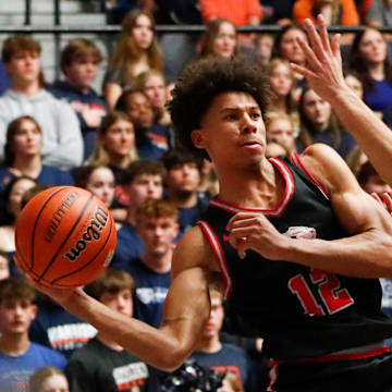 Fishers Tigers Justin Kirby (12) passes the ball past Harrison Raiders forward Malachi King (41) Saturday, March 15, 2025, during the IHSAA boys basketball 4A regional championship game at Frankfort High School in Frankfort, Ind. Fishers won 89-39.