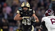 Purdue Boilermakers running back Devin Mockobee runs past Southern Illinois Salukis linebacker Chris Presto 