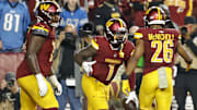 Nov 9, 2025; Landover, Maryland, USA; Washington Commanders wide receiver Robbie Chosen (12) celebrates with Commanders running back Jeremy McNichols (26) after catching a touchdown pass against the Detroit Lions in the third quarter at Northwest Stadium. Mandatory Credit: Geoff Burke-Imagn Images
