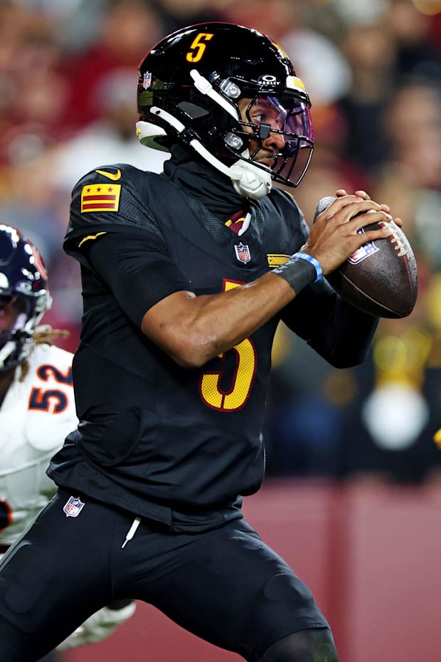 Washington Commanders quarterback Jayden Daniels scrambles out of the pocket against Chicago Bears pass rusher Darrell Taylo