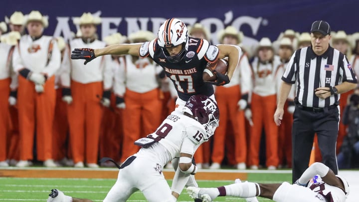 Dec 27, 2023; Houston, TX, USA; Oklahoma State Cowboys wide receiver Leon Johnson III (17) is tackled by Texas A&M Aggies defensive back Bravion Rogers (19) in the second quarter at NRG Stadium. Mandatory Credit: Thomas Shea-USA TODAY Sports