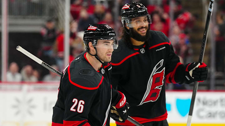 Mar 11, 2025; Raleigh, North Carolina, USA;  Carolina Hurricanes defenseman Sean Walker (26) celebrates his goal with defenseman Jalen Chatfield (5) against the Tampa Bay Lightning during the third period at Lenovo Center. Mandatory Credit: James Guillory-Imagn Images