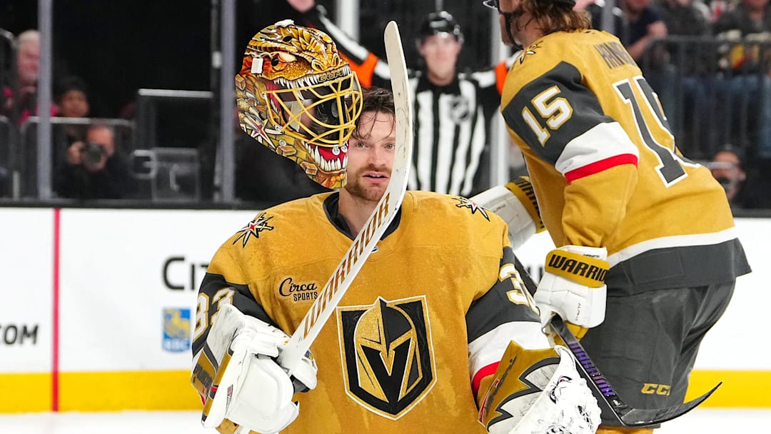 Mar 28, 2026; Las Vegas, Nevada, USA; Vegas Golden Knights goaltender Adin Hill (33) flips his helmet off after a Washington Capitals shot breaks one of the straps during an overtime period at T-Mobile Arena. Mandatory Credit: Stephen R. Sylvanie-Imagn Images