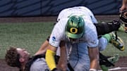 Oregon’s Anson Aroz, right, collides with Utah Valley catcher Mason Strong at the plate in the eighth inning of the Eugene NCAA Regional at PK Park.