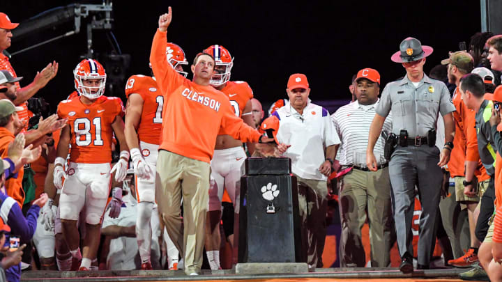 Clemson head coach Dabo Swinney points up while rubbing Howard's Rock