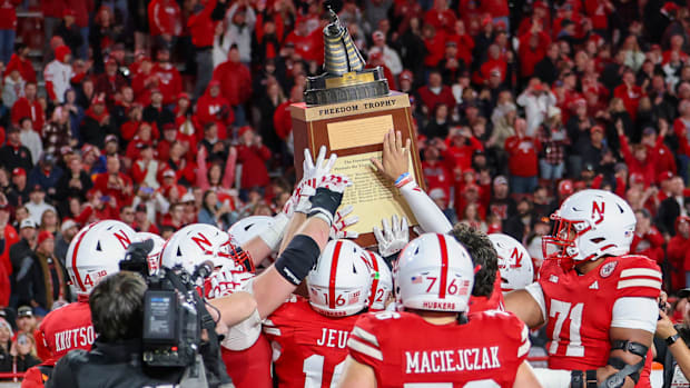 Nebraska players hoist the Freedom Trophy after defeating Wisconsin, 44-25