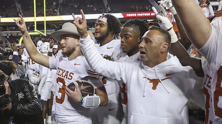 Nov 30, 2024; College Station, Texas, USA; Texas Longhorns quarterback Quinn Ewers (3) celebrates with head coach Steve Sarkisian and teammates after the game against the Texas A&M Aggies at Kyle Field. Mandatory Credit: Troy Taormina-Imagn Images