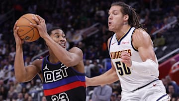 Nov 20, 2023; Detroit, Michigan, USA;  Detroit Pistons guard Jaden Ivey (23) is defended by Denver Nuggets forward Aaron Gordon (50): Rick Osentoski-Imagn Images