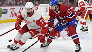 Apr 8, 2025; Montreal, Quebec, CAN; Detroit Red Wings forward Dylan Larkin (71) plays the puck and Montreal Canadiens forward Josh Anderson (17) forechecks during the second period at the Bell Centre. Mandatory Credit: Eric Bolte-Imagn Images