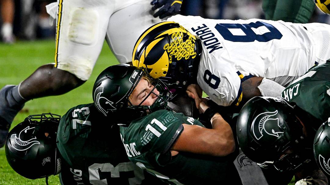 Michigan State's Alessio Milivojevic, bottom, is sacked by Michigan's Derrick Moore during the fourth quarter on Saturday, Oct. 25, 2025, at Spartan Stadium in East Lansing.