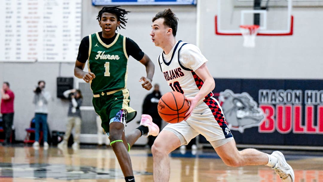 East Lansing's Cameron Essell, right, moves the ball as Ann Arbor Huron's Kaleb Brown closes in during the first quarter on Tuesday, March 11, 2025, at Mason High School.