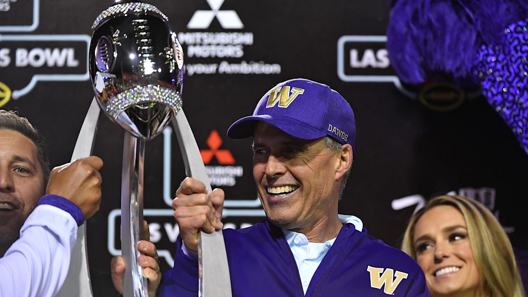 Washington Huskies head coach Chris Petersen holds the Las Vegas Bowl trophy  Stadium. Mandatory Credit: Stephen R. Sylvanie-Imagn Images