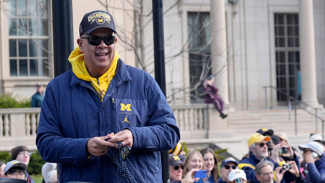 Michigan Athletic Director Warde Manuel is all smiles as he looks to throw beads to fans on South University during the Michigan men's basketball team’s national championship parade through the University of Michigan campus in Ann Arbor on Saturday, April 11, 2026. Michigan Athletic Director Warde Manuel is all smiles as he looks to throw beads to fans on South University during the Michigan men's basketball team’s national championship parade through the University of Michigan campus in Ann Arbor on Saturday, April 11, 2026.