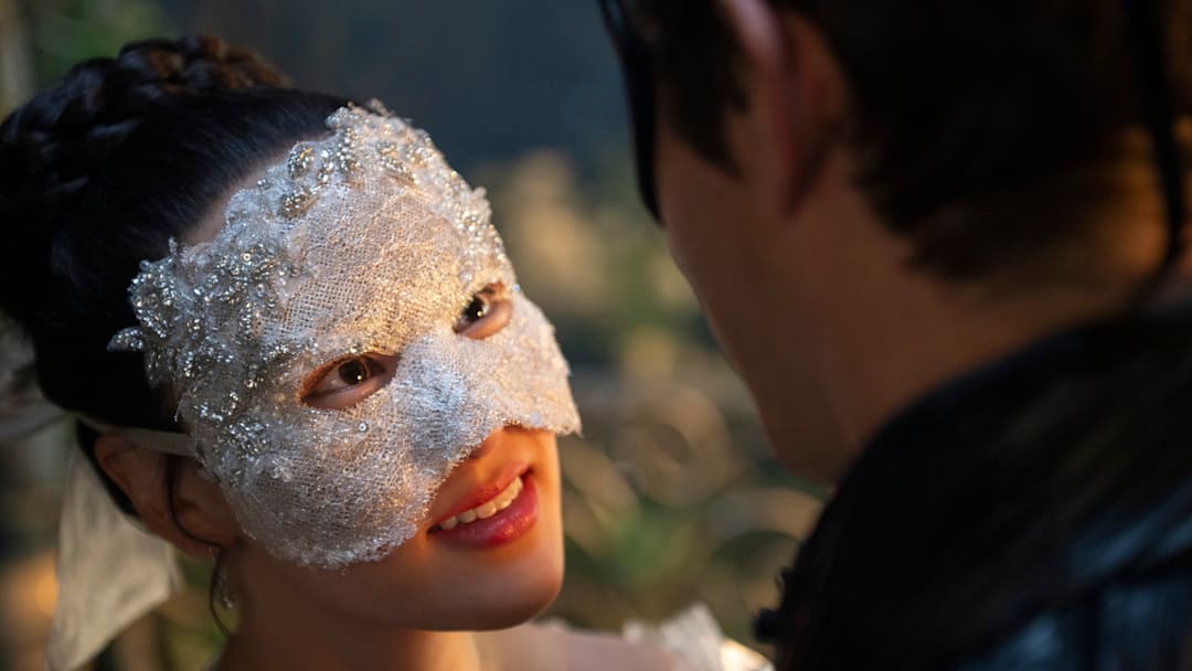 A woman in a bejeweled mask stares upwards in a still from 'Bridgerton' season four