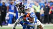 Detroit Lions running back David Montgomery runs against Denver Broncos safety Justin Simmons during the first half at Ford Field in Detroit on Saturday, Dec. 16, 2023.