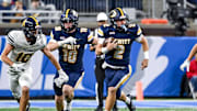 DeWitt's Traverse Moore, right, runs for a gain against Mount Pleasant during the second quarter in the Division 3 football state final on Sunday, Nov. 30, 2025, at Ford Field in Detroit.