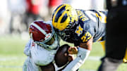 Michigan linebacker Michael Barrett tackles Alabama quarterback Jalen Milroe at the Rose Bowl